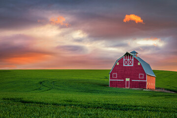 Dramatic sunset over a red barn in the Palouse in eastern Washington state
