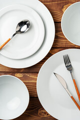 White ceramic tableware on wooden background top view