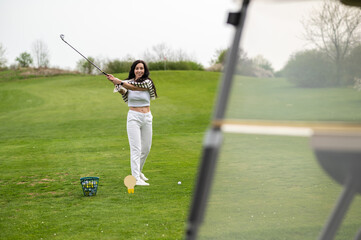 Joyful girl golfer playing golf in nature during the summer