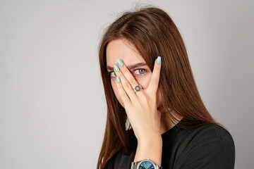 Young Woman Covering Face With Hands in Studio