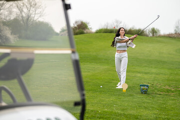 Joyful girl golfer playing golf in nature during the summer