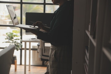 Female Manager Using Laptop Computer To Check Inventory. In the Background Warehouse Retail Center with Cardboard boxes, e-Commerce Online Orders, Food, Medicine, Products Supply. Over the Shoulder