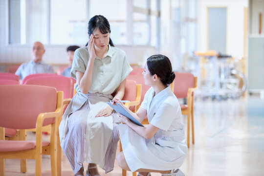 待合室で問診する看護師と患者