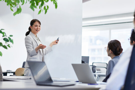 ホワイトボードを使い会議をするビジネスウーマン