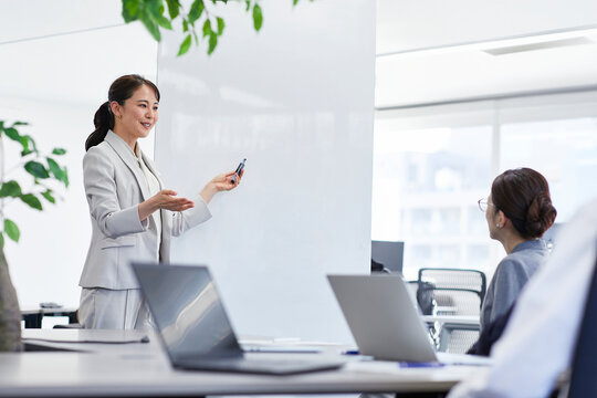 ホワイトボードを使い会議をするビジネスウーマン