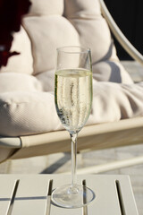 Champagne glass on small oustide outdoor table on patio