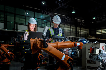 Fototapeta premium team engineers inspecting on machine with smart tablet. Worker works at heavy machine robot arm. The welding machine with a remote system in an industrial factory. Artificial intelligence concept.