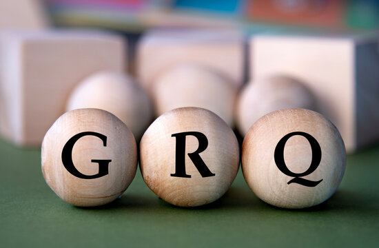 CRQ - acronym on wooden balls on the background of wooden large cubes