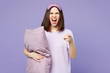 Young indignant sad mad woman wear pyjamas jam sleep eye mask at home hold pillow snoring scream...