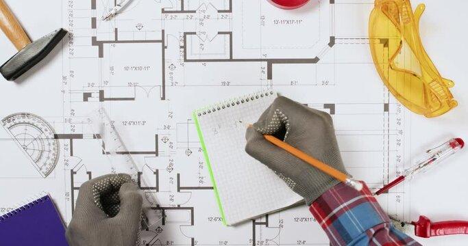 Designer writes and crosses wrong marks on apartment floor plan upper view. Engineer seeks solution for building on construction drawing