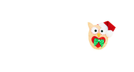The toy owl is isolated on the white background with copy space. The atmosphere of Christmas and New Year. Christmas banner, mock-up