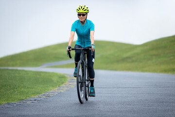 Fototapeta premium Woman biking on summer mountain trail