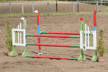  Horse obstacle course outdoors summertime. Poles in the sand for equestrian event