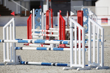  Horse obstacle course outdoors summertime. Poles in the sand for equestrian event