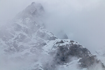 Snowy mountain peaks in clouds