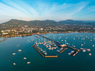Aerial drone view of Chalong pier with many boats at sunrise, Phuket, Thailand
