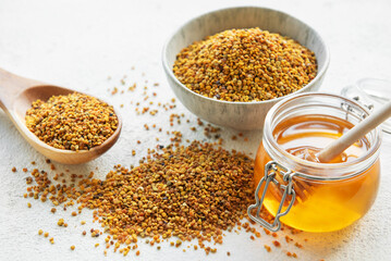 Raw organic bee pollen and honey in jars. .
