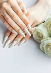 Fototapeta premium Female Hands on a white background with beautiful pearl manicure