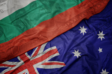 waving colorful flag of bulgaria and national flag of australia on the dollar money background. finance concept.