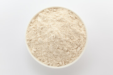 Organic Wheat flour (Triticum) in a white ceramic bowl. Isolated on a white background. Top View