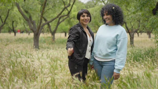 woman fondly putting a flower in her female friend hair.MOV