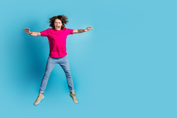 Fototapeta premium Full size photo of nice young man jump fall empty space wear t-shirt isolated on blue color background
