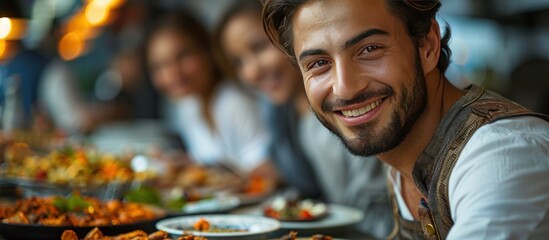 Obraz premium Man Smiling at the Camera in a Restaurant Setting