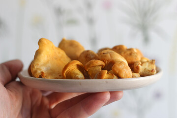 Fresh chanterelle mushrooms on a plate in the hand.