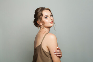 Fototapeta premium Cheerful good-looking woman with updo hairstyle and makeup. Young female model portrait