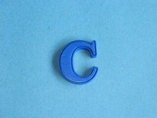 Macro photo or closeup photo of the alphabet from children's toys on a blue background. Use on...