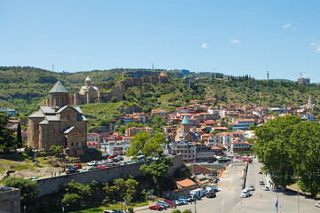 Fototapeta premium Beautiful landscape of Tbilisi and Metekhi church on the background of green mountains
