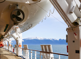 Bottom view of lifeboat mounted on a large cruise ship. Snow Capped mountains in the distance....