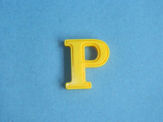 Macro photo or closeup photo of the alphabet from children's toys on a blue background. Use on...