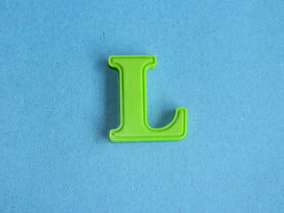 Macro photo or closeup photo of the alphabet from children's toys on a blue background. Use on...