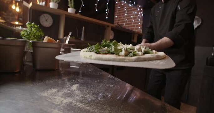 Pizza chef puts the pizza in the oven with an open flame, Neapolitan pizza
