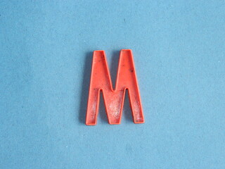 Macro photo or closeup photo of the alphabet from children's toys on a blue background. Use on...