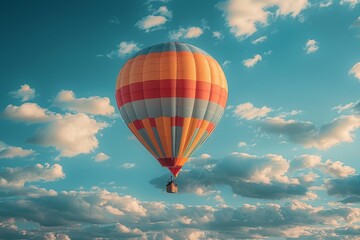 Fototapeta premium An orange and red hot air balloon ascends in a clear blue sky, symbolizing adventure and leisure