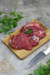 Daging sapi mentah or raw beef on preparation for cooking with some spice. Beef on Eco friendly package and chopping board with wooden rustic background.