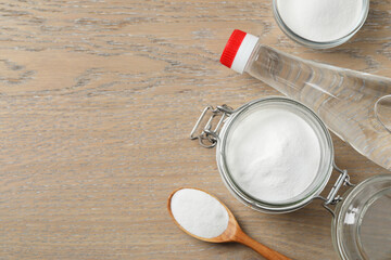 Baking soda and vinegar on wooden table, flat lay. Space for text