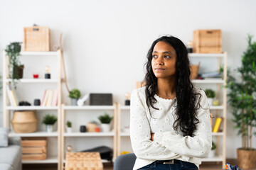 Serious Indian young woman thinking at home