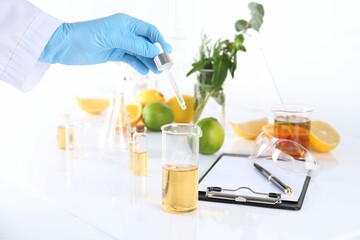 Aromatherapy product. Scientist developing essential oils at white table in laboratory, closeup