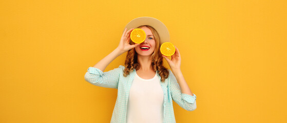 Summer portrait of happy joyful young woman with slices of orange fruit, cheerful girl smiles in hat