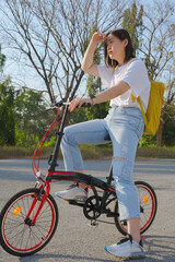 Naklejka premium spring is comming concept with happy and cheerful feeling of asian woman riding bicycle
