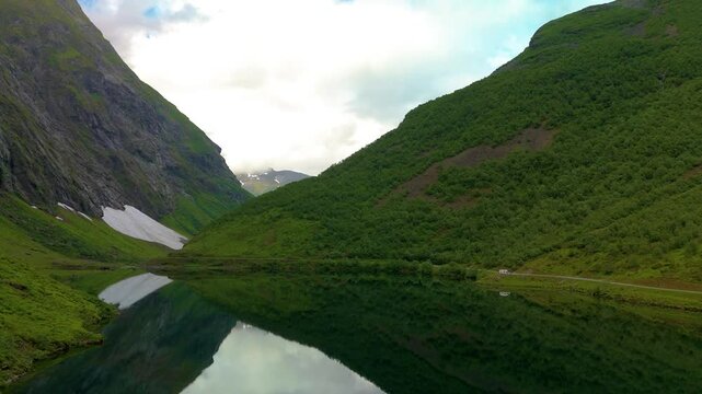 An impressive aerial view of a peaceful lake in a valley, surrounded by grand mountains, capturing the beauty of nature in all its glory, Norweigan Fjords Stavbergvatnet Urke