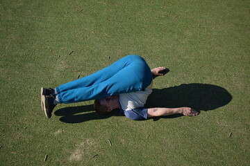 A focused young athlete dynamically performing warm-up drills and stretches outdoors. Clad in...