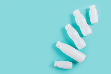 Top view of white plastic bottles on blue background, representing commitment to zero waste living and eco-friendly habits.