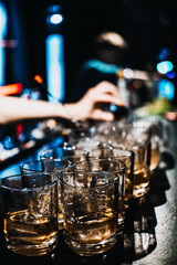 Bartender Preparing Multiple Whiskey Cocktails at a Busy Bar