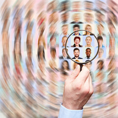 Hand mit Lupe sucht in Vielzahl von Portraits die richtigen Angestellten