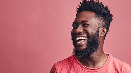 Obraz premium A smiling black man with a beard stands in front of a pink wall