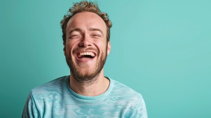 Obraz premium Man with curly hair laughs against a turquoise background